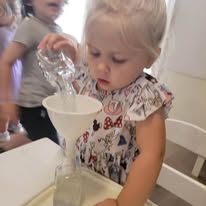 Preschool child practicing a pouring activity